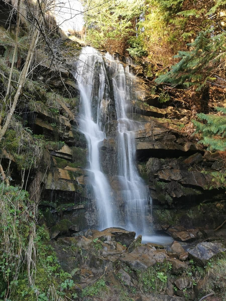 Cascada de Ur Jauziak, con el agua cayendo entre las rocas del bosque