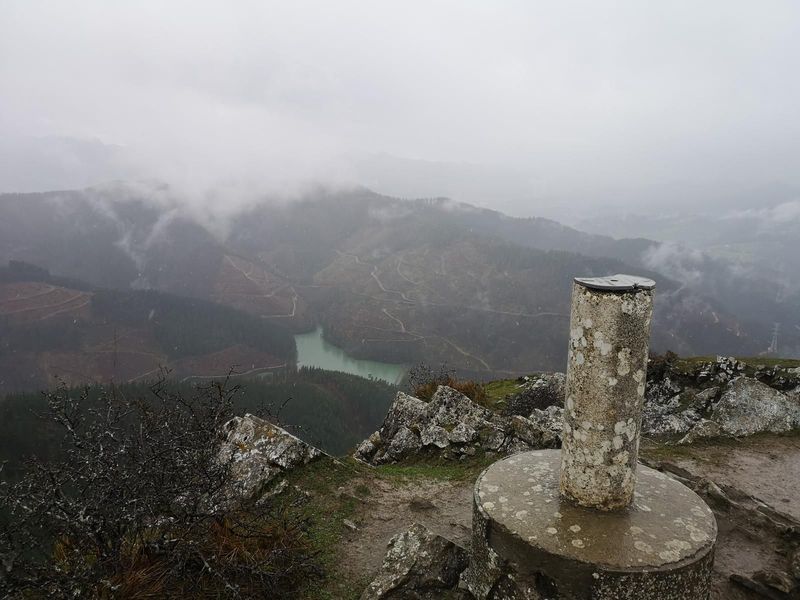 El v&eacute;rtice de Egoarbitza con niebla, y el embalse de Aixola abajo
