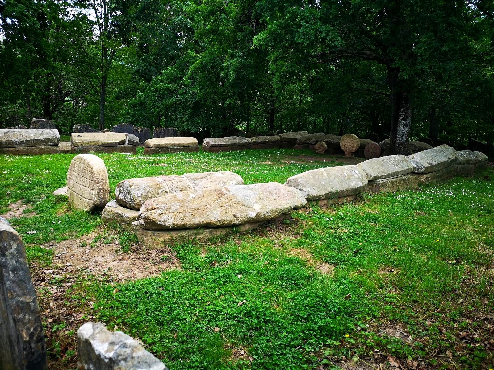 Sarc&oacute;fagos de piedra de la Necr&oacute;polis de Argi&ntilde;eta, entre el c&eacute;sped y los &aacute;rboles