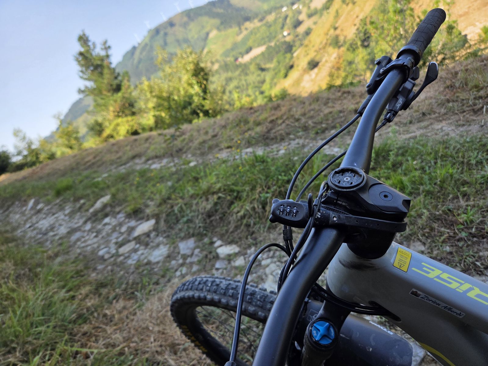 E-bikearen manillarra lehen planoan pistaren gainean, mendiaren hegala atzealdean