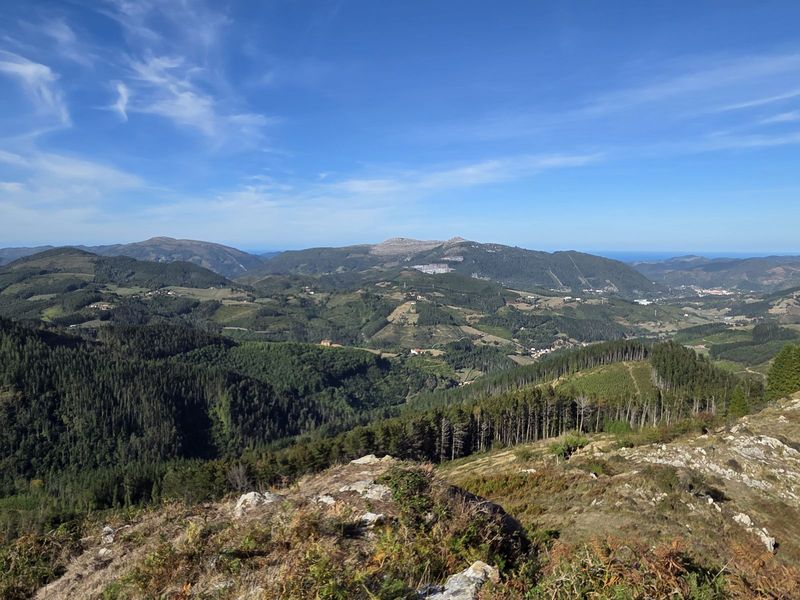 Vista panor&aacute;mica del valle, con caser&iacute;os, monta&ntilde;as y el mar al fondo