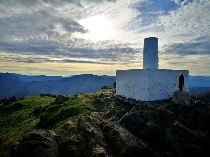 V&eacute;rtice geod&eacute;sico a contraluz al atardecer, con una marca roja en primer plano