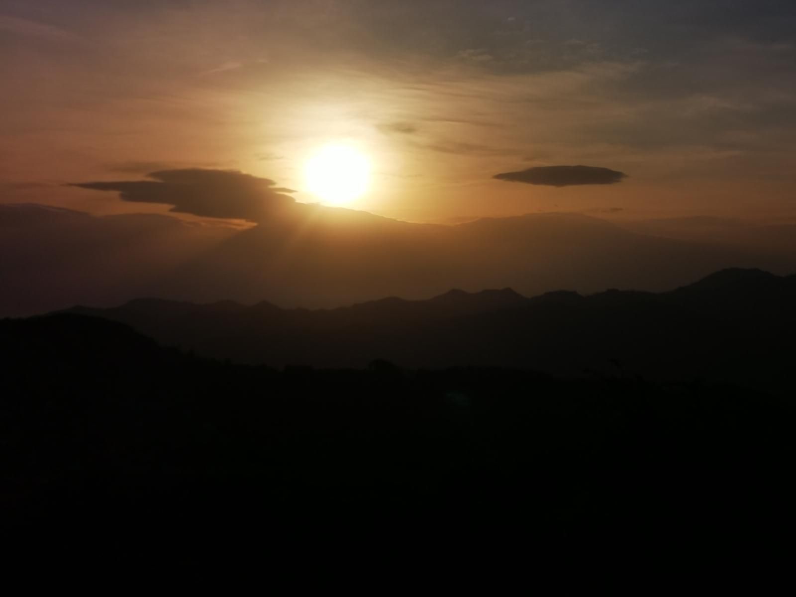 Amanecer con el sol asomando entre nubes, desde la zona de Urko
