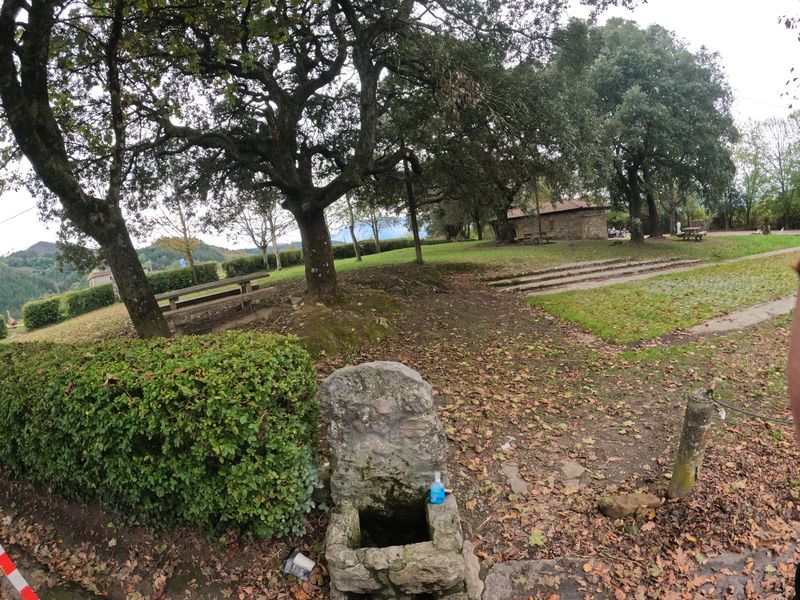 La fuente de piedra de Goierri, junto al merendero con mesas bajo los robles