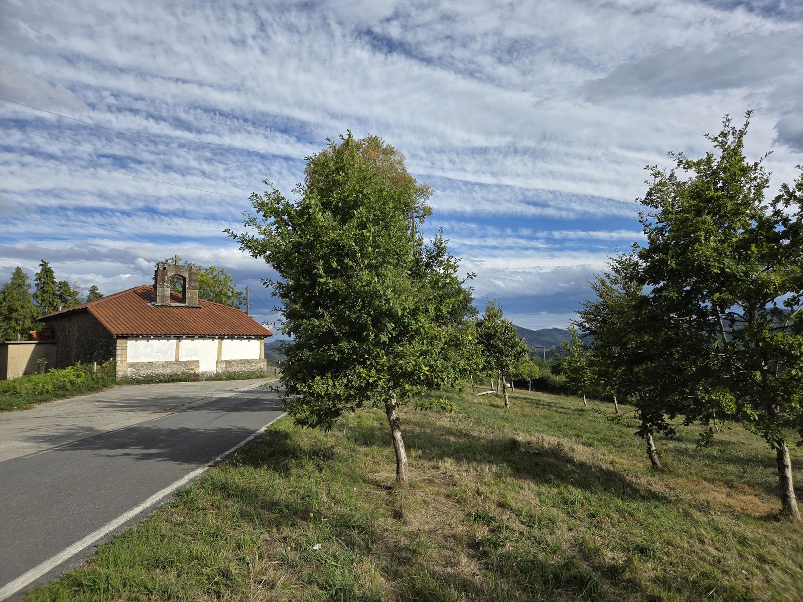 Ermita de piedra con espada&ntilde;a y tejado de teja, junto a la carretera