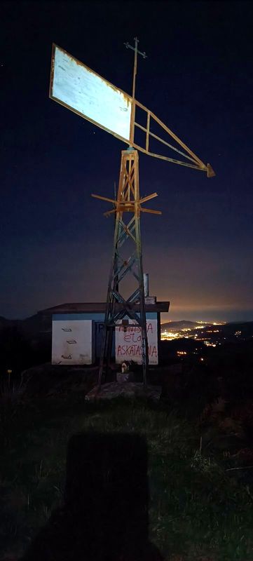Intxorta gauez: metalezko dorretxoa bere palarekin eta etxola pintatua, haraneko herrien argiak hondoan