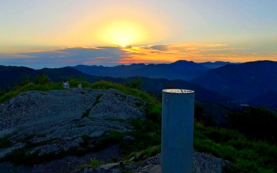 Amanecer entre nubes junto al mojón de la cumbre de Urko, km 7,9 de la ruta