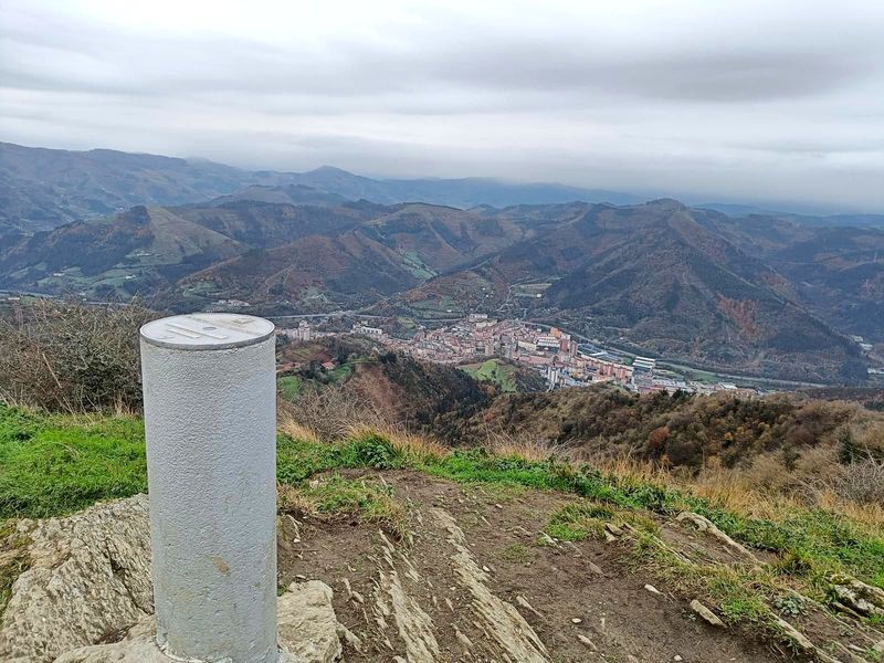 Moj&oacute;n en la cima con vistas a un pueblo en el valle al fondo