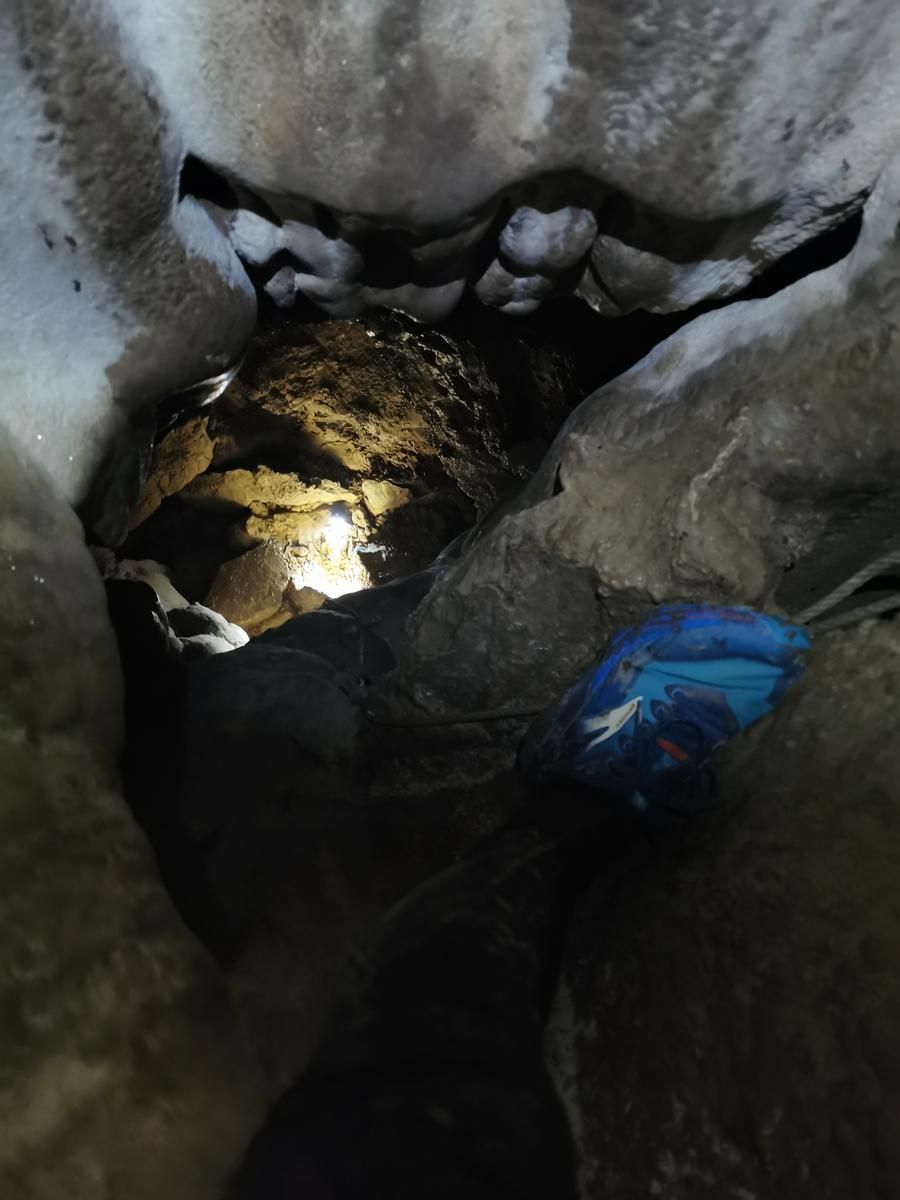 Vista hacia el pozo interior de la cueva, con una cuerda preparada para el descenso