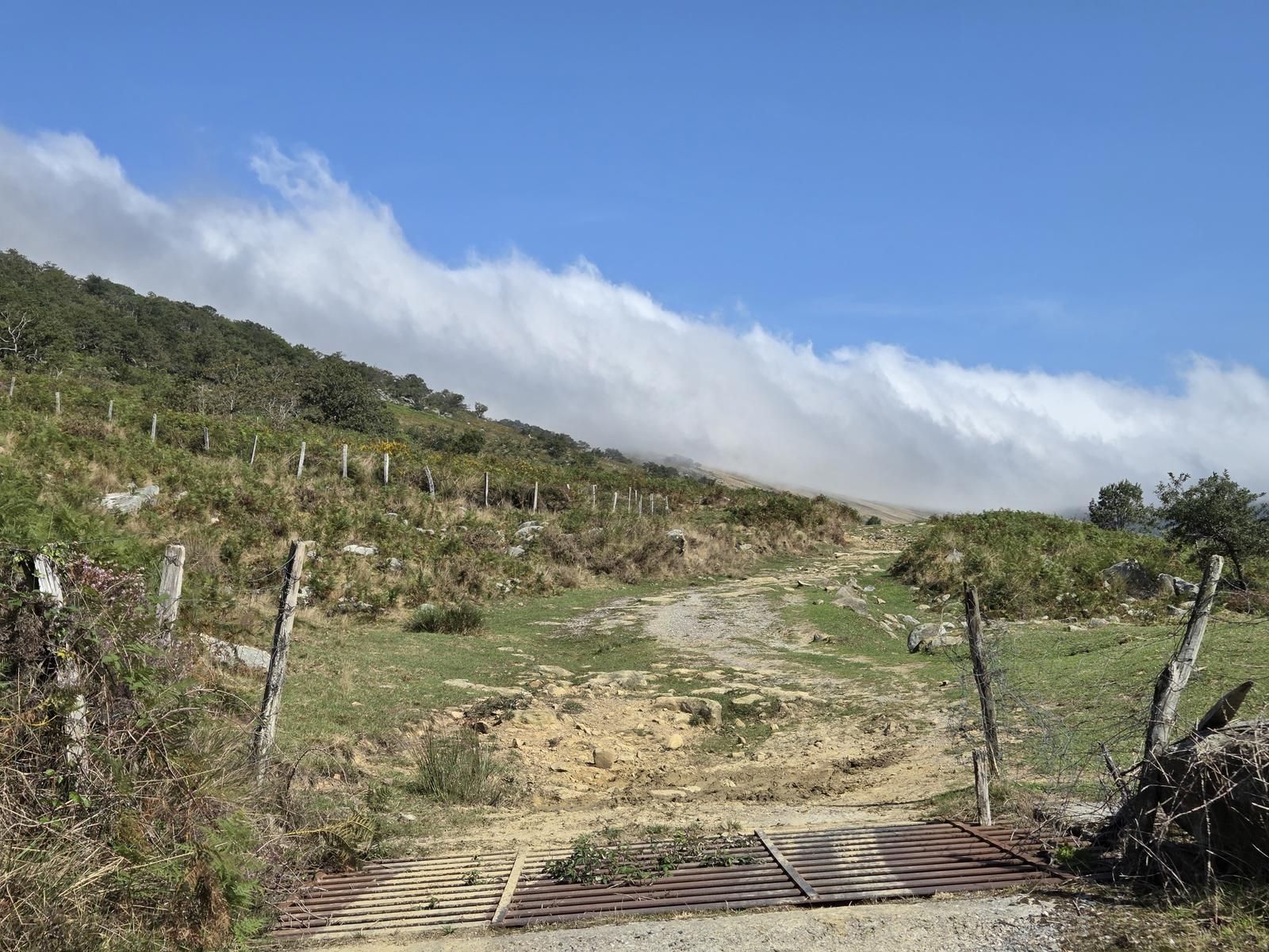 Descenso por un camino de piedra hacia Garai, con un paso canadiense entre la niebla