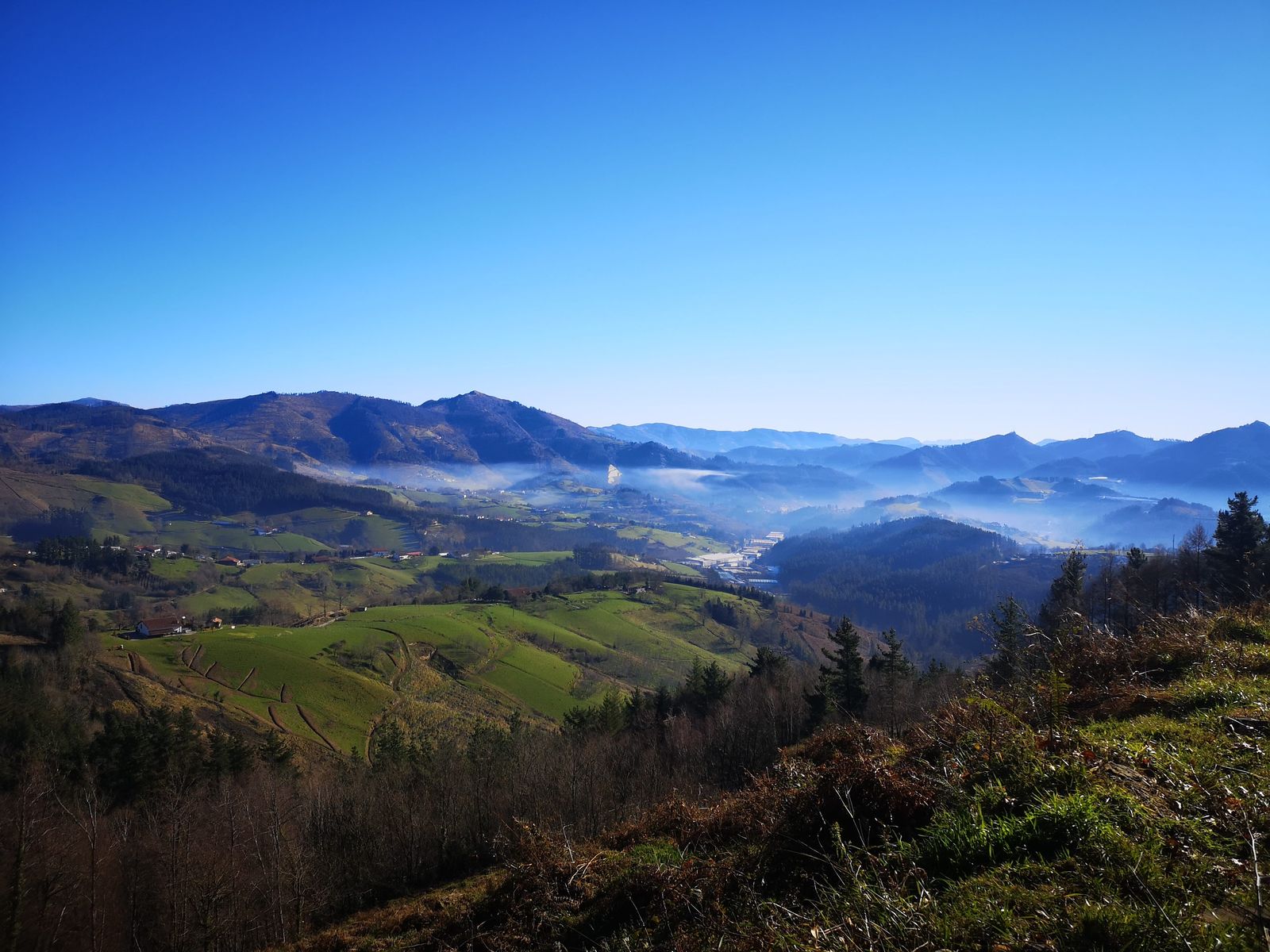 Haranaren ikuspegi panoramikoa, lainoa behean eta industrialdea hondoan