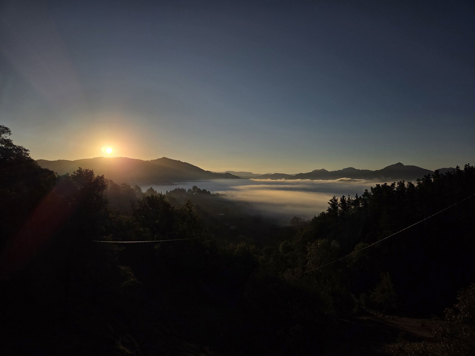 Amanecer con niebla en el valle, con el sol saliendo tras los montes