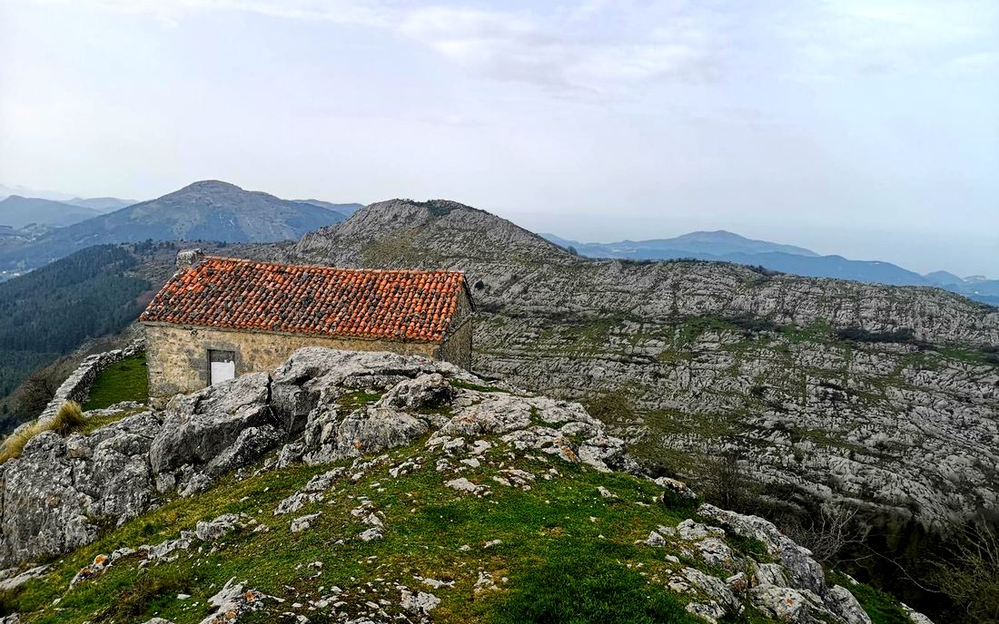Ermita de Santa Eufemia en la cima, con tejado de teja y vistas amplias sobre varias sierras