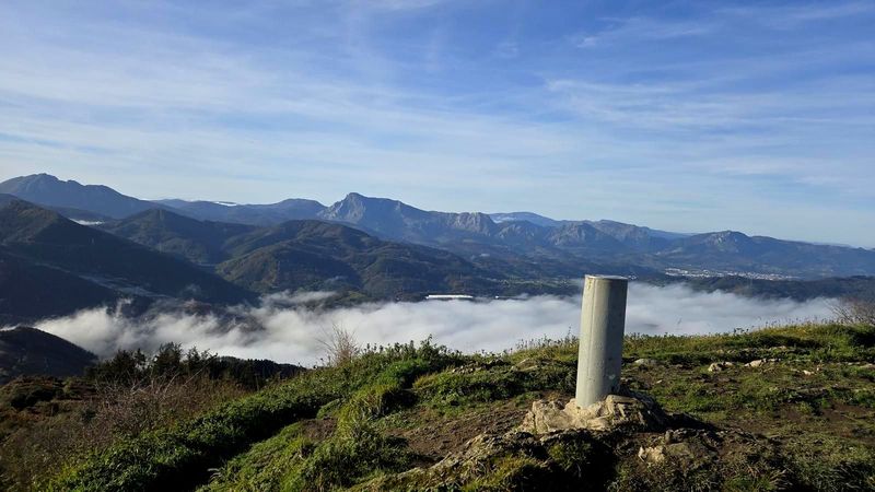 Urkoko gailurreko bertize geodesikoa, hodei baxuekin eta inguruko mendiak atzealdean
