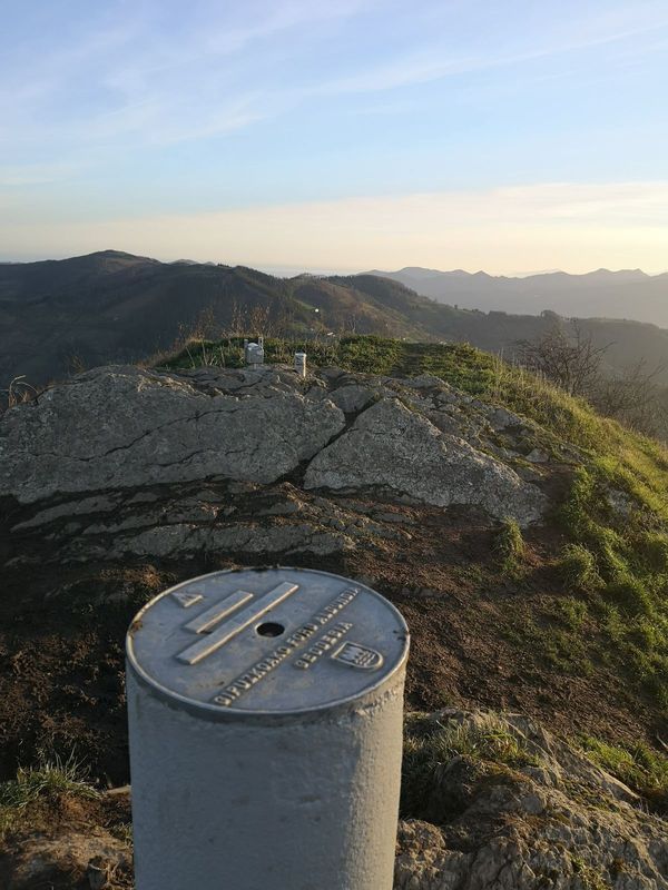 Urkoko bertize geodesikoaren plaka, Bizkaia eta Gipuzkoaren arteko mugan, gandorra atzealdean