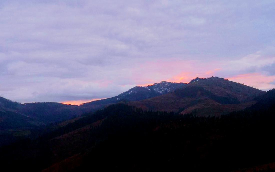 Amanecer con luz anaranjada sobre las montañas, al salir de Trabakua