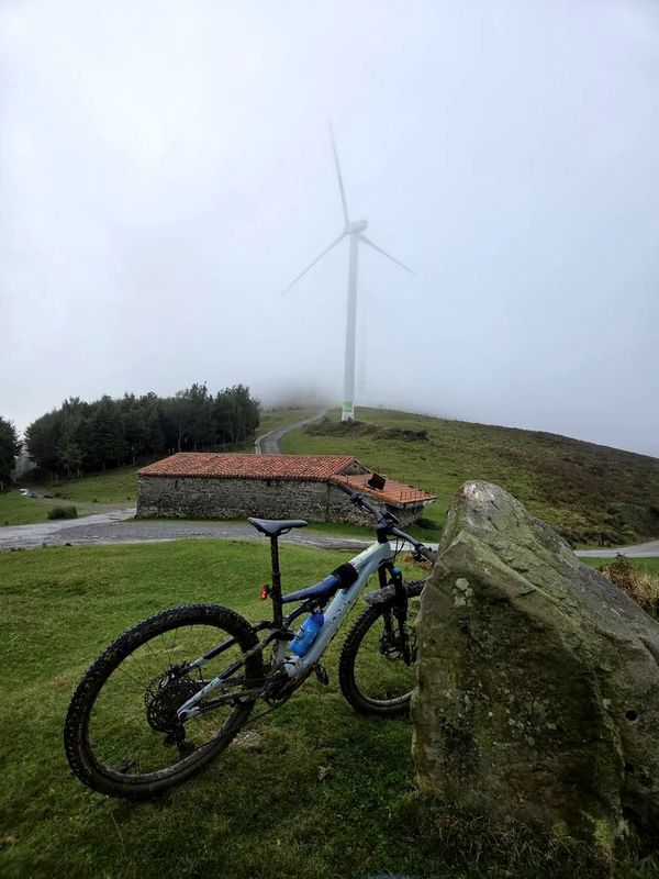 Bicicleta junto a un aerogenerador entre la niebla, cerca de Zengotitagane, km 27,7