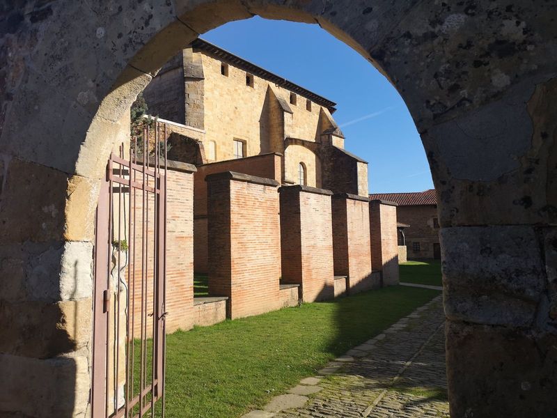 Vista del Monasterio de Zenarruza a trav&eacute;s de un arco de piedra, con la iglesia y el muro del claustro al fondo